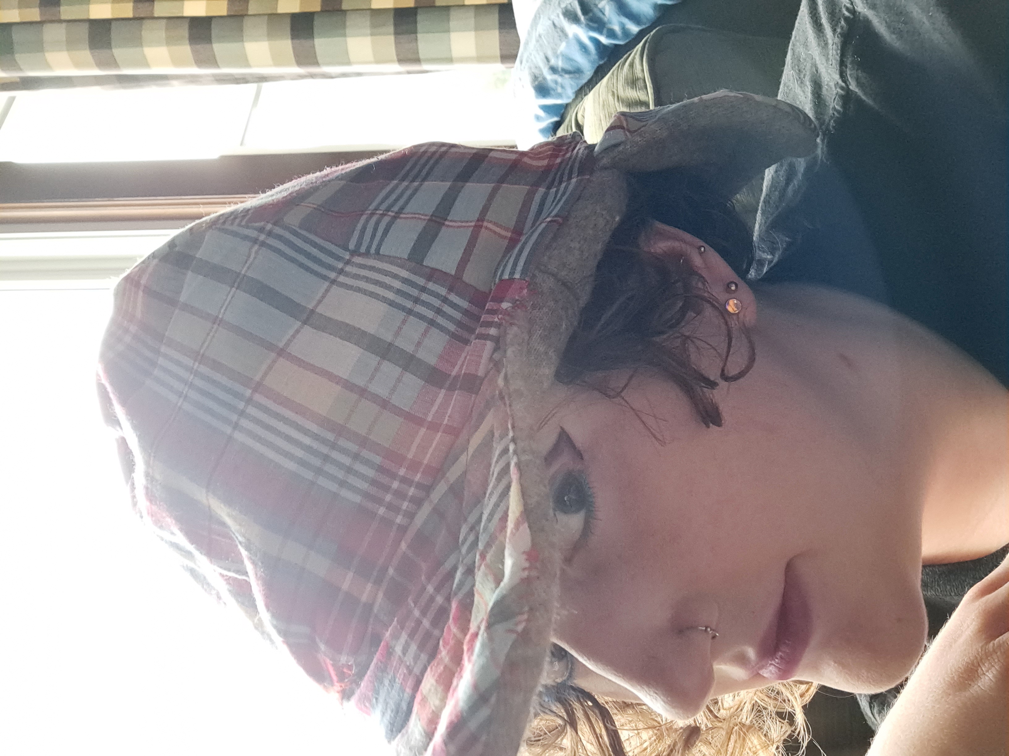 Allison wearing a plaid hat with a brim and an earmuff/neck covering panel