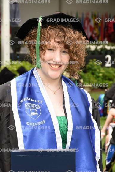 picture of Allison at graduation, wearing her handmade blue satin stole on top of her robes