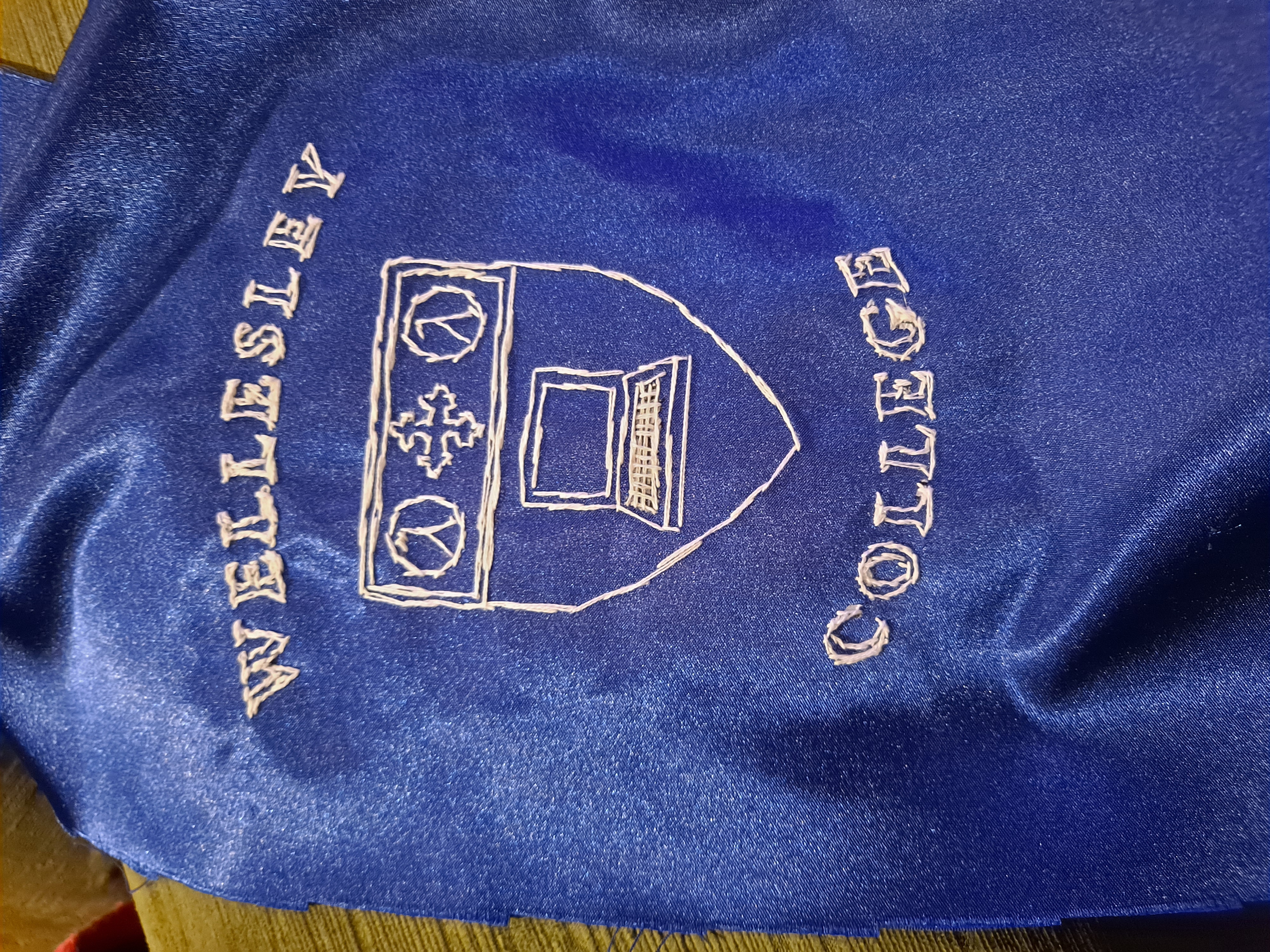 picture of Allison's hand-embroidered rendering of the Wellesley College CS department's logo, which features a laptop and lambda symbols on a shield